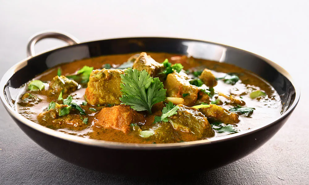Spiced meat curry in creamy sauce, garnished with fresh cilantro leaves at Lahana Indian Cuisine, a Authentic Indian Cuisine Restaurant in New York