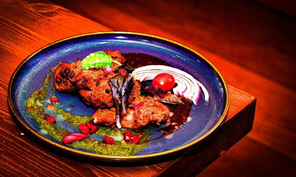 Grilled Meat Grilled meat with green sauce and garnishes at Lahana Indian Cuisine, a Authentic Indian Cuisine Restaurant restaurant in New York