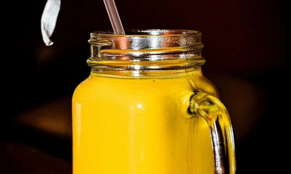 Smoothie Yellow smoothie in a glass jar with a straw at Lahana Indian Cuisine, a Authentic Indian Cuisine Restaurant restaurant in New York