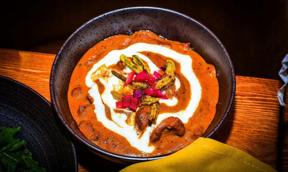 Korma Curry Creamy orange curry with yogurt swirl and garnishes at Lahana Indian Cuisine, a Authentic Indian Cuisine Restaurant restaurant in New York